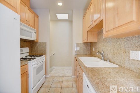 A kitchen with wooden cabinets and a white refrigerator.