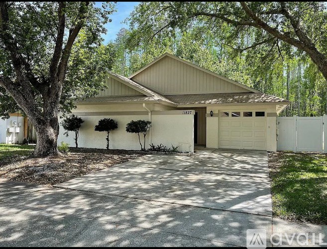 A house with a garage and a driveway in front of it.