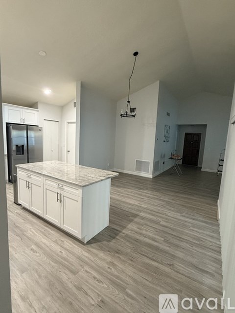 A kitchen with a white countertop and cabinets with a modern design.