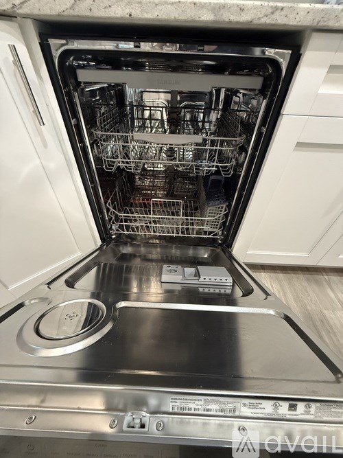 A stainless steel oven with the door open showing the racks inside.