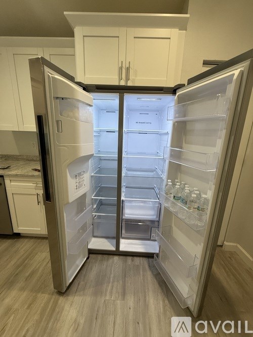 A white refrigerator with its door open and empty.