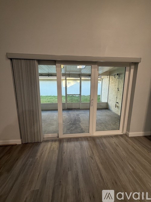 A room with a sliding glass door leading to a balcony.