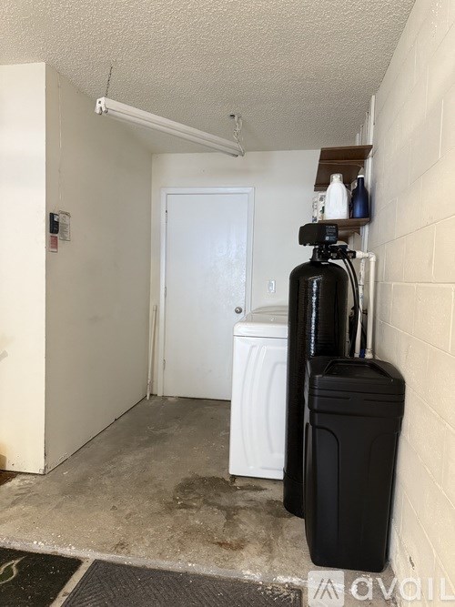 A black suitcase is leaning against a wall in a room with a white door.