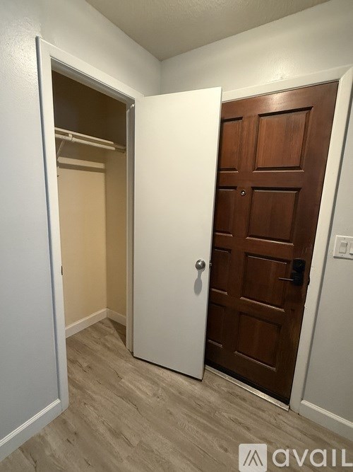 A white door is open to a room with a brown door.