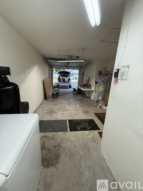 A garage with a black mat on the floor and a white wall.
