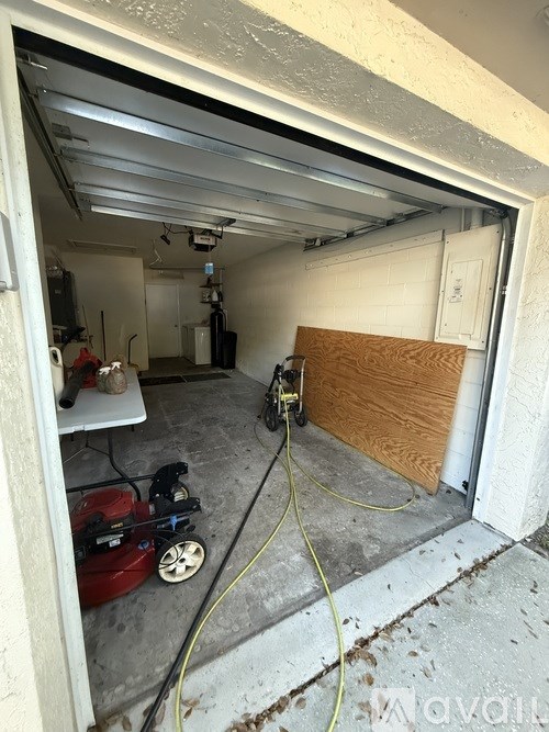 A garage with a red machine and a yellow extension cord.