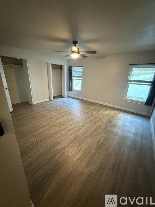 A room with wooden flooring and a ceiling fan.