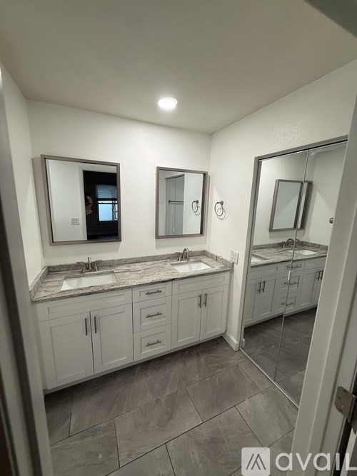 A bathroom with two sinks and a large mirror.