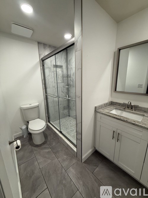 A bathroom with a toilet, sink, and shower.
