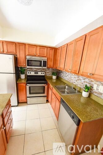 A kitchen with orange cabinets and a white refrigerator.