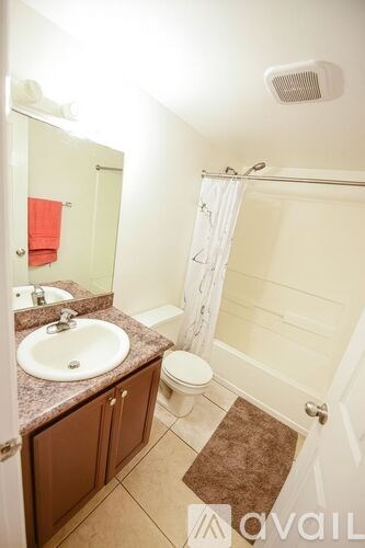 A bathroom with a toilet, sink, and shower.