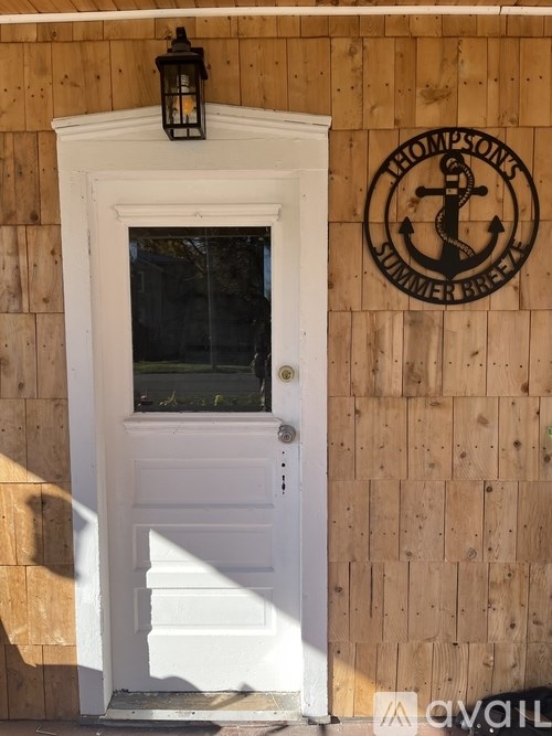 A white door with a window and a sign on the wall.