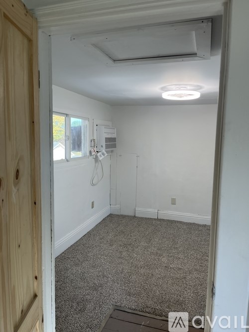 A room with a carpeted floor and a ceiling fan.
