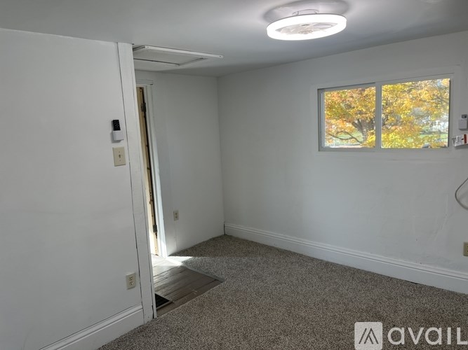 A room with a window showing autumn leaves outside.