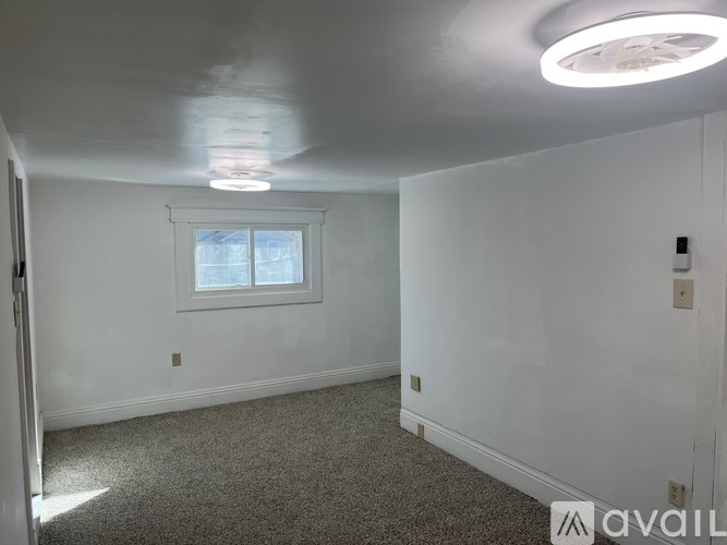 A room with a window and carpeted floor.