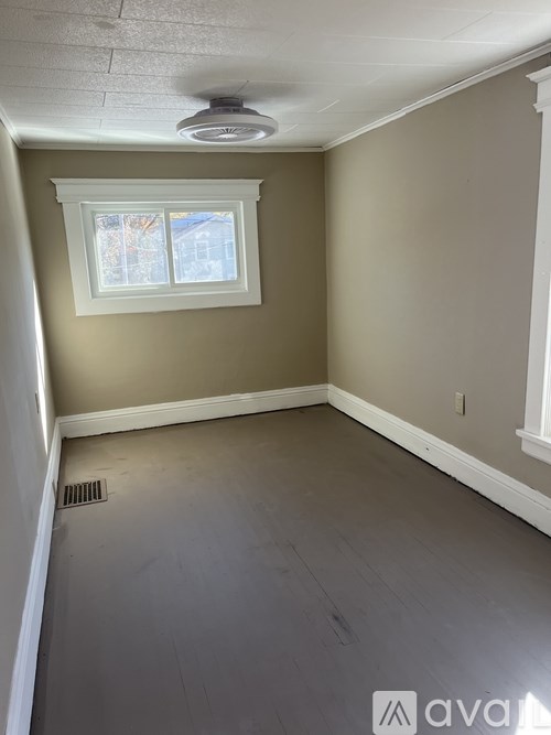 A room with a window and a ceiling fan.