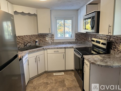 A kitchen with granite countertops and white cabinets.