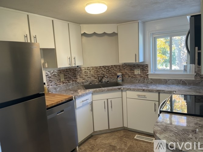 A kitchen with a stone backsplash and marble countertops.