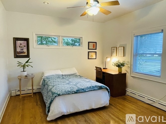 A bedroom with a bed, nightstand, and a ceiling fan.