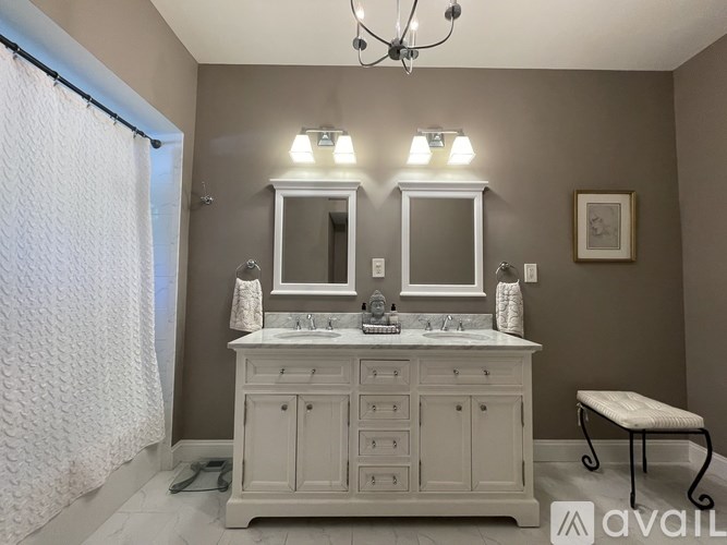 A bathroom with a vanity and a chandelier.