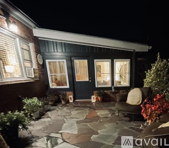 A house with a dark blue exterior and a stone patio.