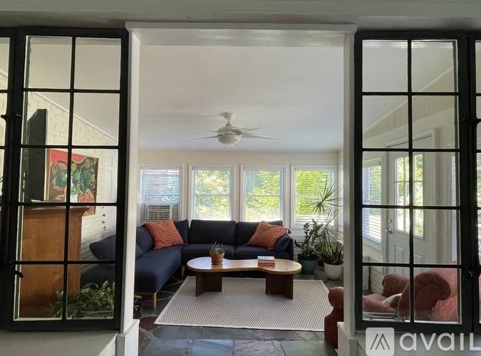 A living room with a blue couch and a ceiling fan.