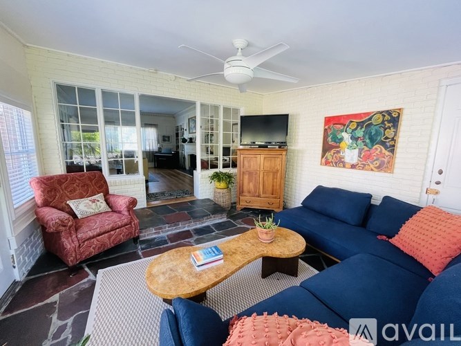 A living room with a red armchair, a blue sofa, and a wooden coffee table.