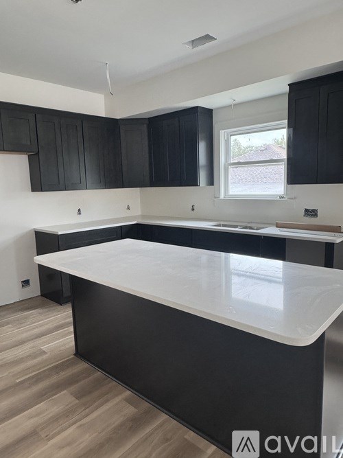 A kitchen with black cabinets and a white countertop.