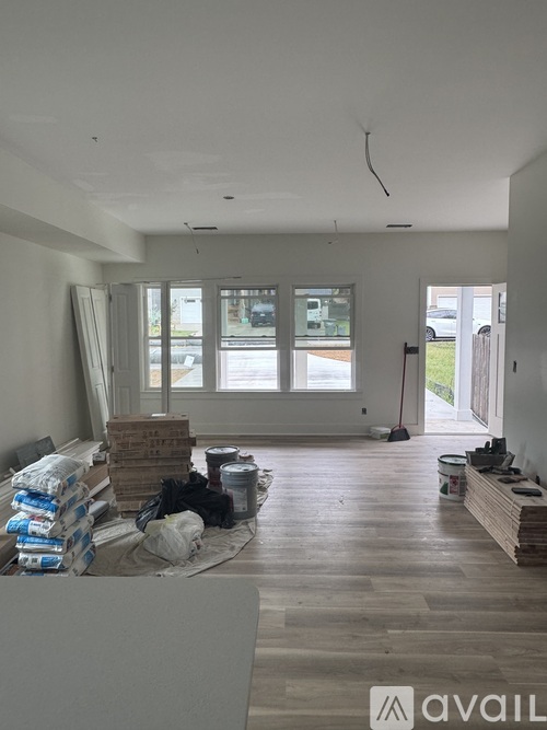 A room under construction with wooden flooring and unfinished walls.