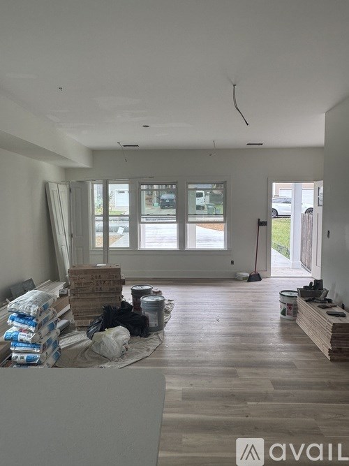 A room under construction with wooden flooring and unfinished walls.