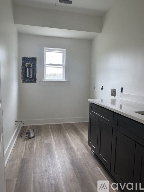 A kitchen with black cabinets and a window.