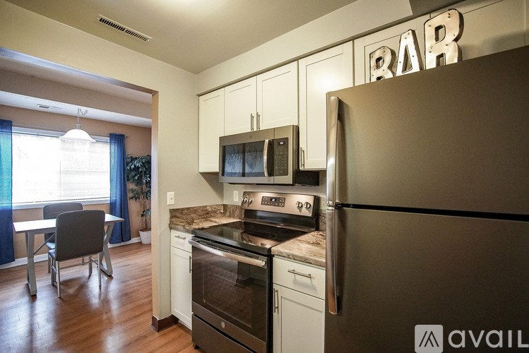 A kitchen with a refrigerator and a bar sign.