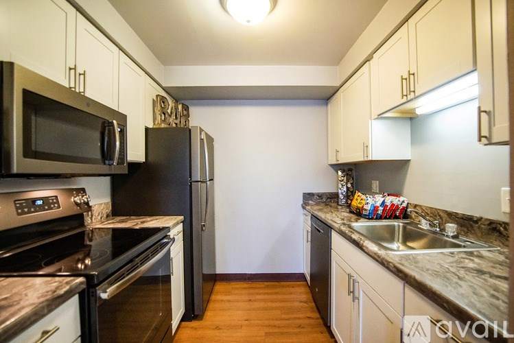A kitchen with black appliances and white cabinets.