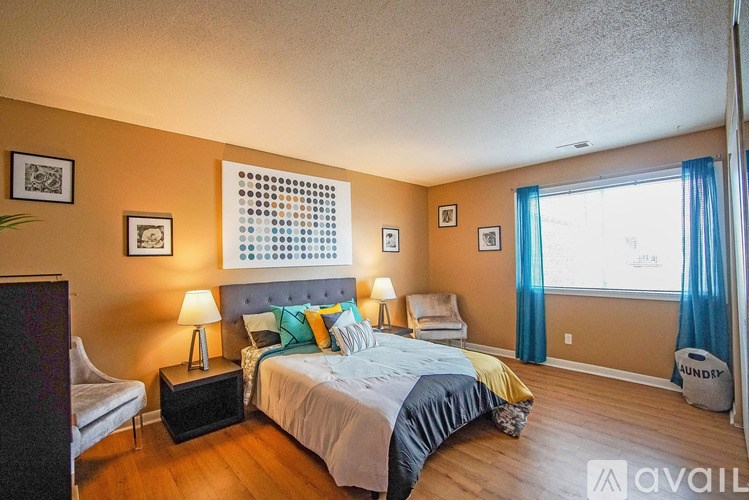 A bedroom with a bed, nightstands, and a chair.