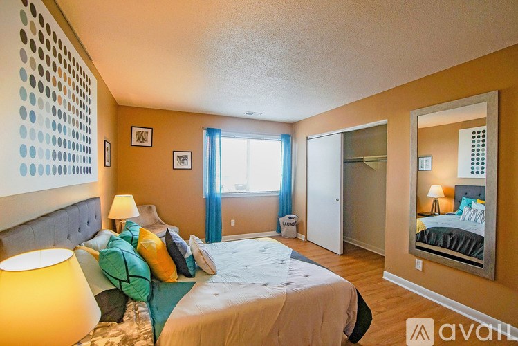 A bedroom with a bed, two lamps, and a mirror.