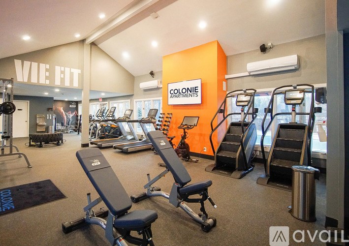 A gym with a variety of equipment including treadmills, weights, and exercise machines.