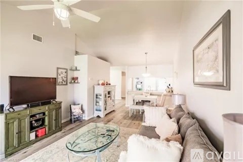 A living room with a glass coffee table and a television.