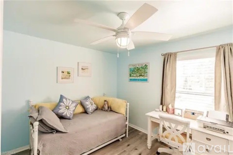 A bedroom with a bed, desk, and window.