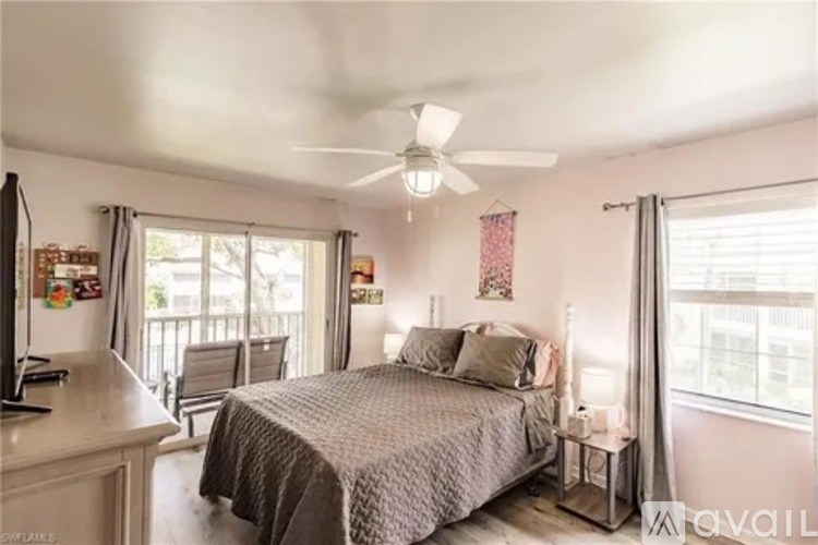 A bedroom with a bed, nightstand, and a ceiling fan.
