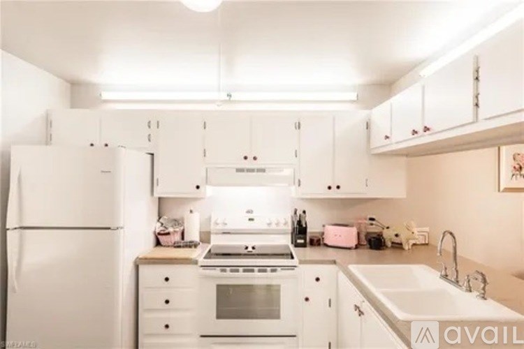 A kitchen with white appliances and cabinets.