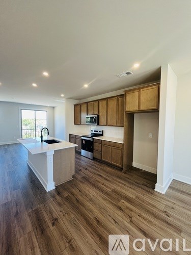 A kitchen with wooden cabinets and a white island.