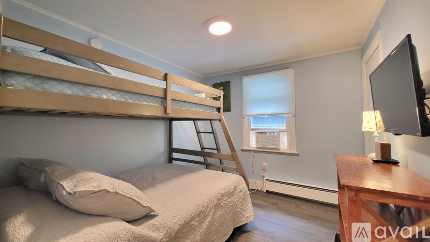 A bedroom with a bunk bed and a ladder.