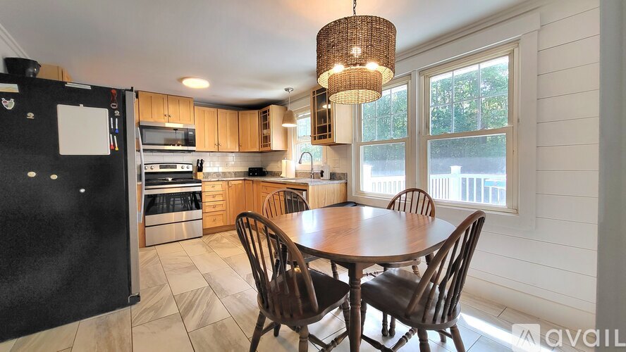 A kitchen with a table and chairs in front of a window.
