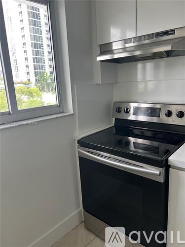 A modern kitchen with a stove and a window.