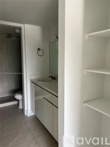 A bathroom with a toilet, sink, and shower.
