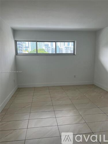 A room with a window and tiled flooring is available for rent.