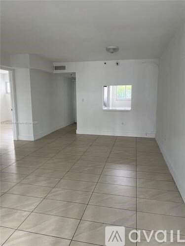 A spacious room with tiled flooring and a window.