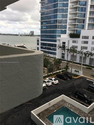 A view of a parking lot with a building in the background and a sign that says "Avail".