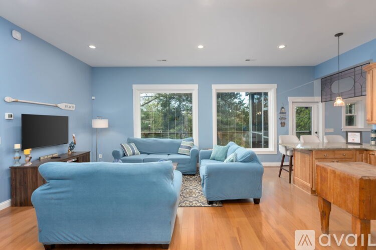 A living room with blue furniture and a flat screen TV.