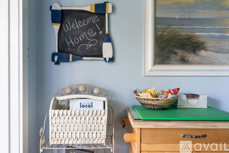 A welcome home sign hangs on a wall above a basket and a basket with a sign that says local.